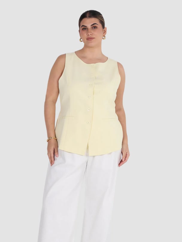 Model in yellow button vest top.