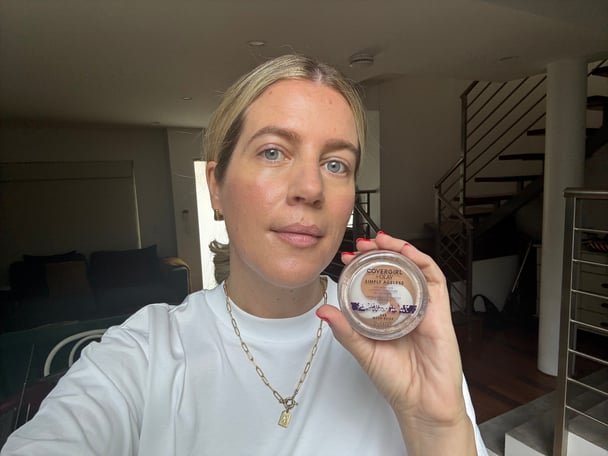 woman holding covergirl foundation