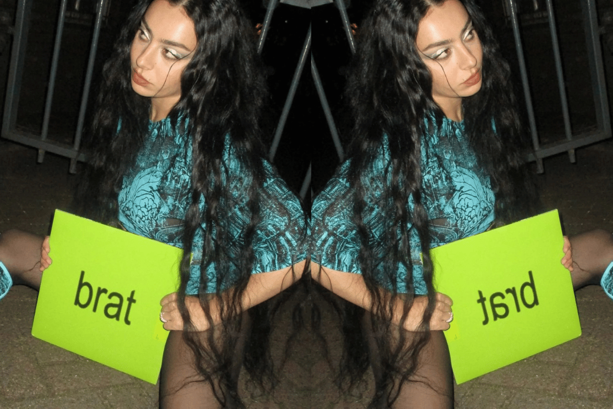 Charli XCX poses in a 'brat' outfit with a record of the same name.