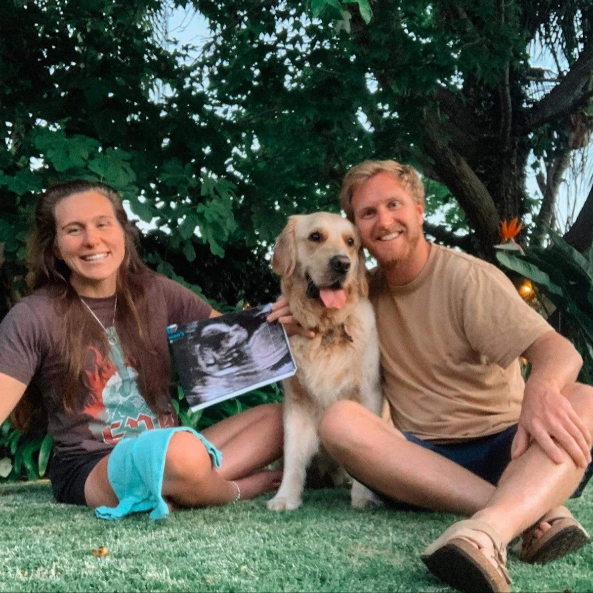 Couple Mitch Brown and Georgia Inglis announcing their pregnancy with their golden retriever. 