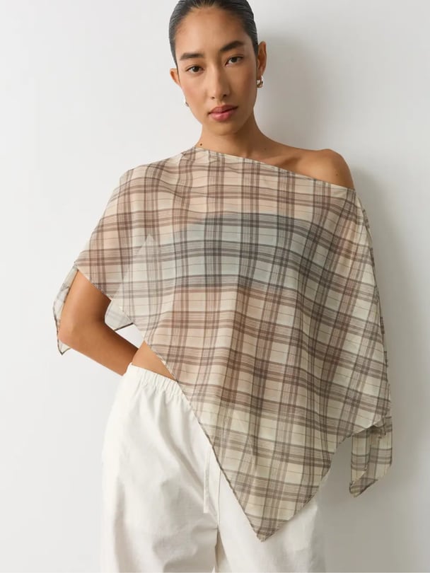 Model wears sheer gingham poncho.