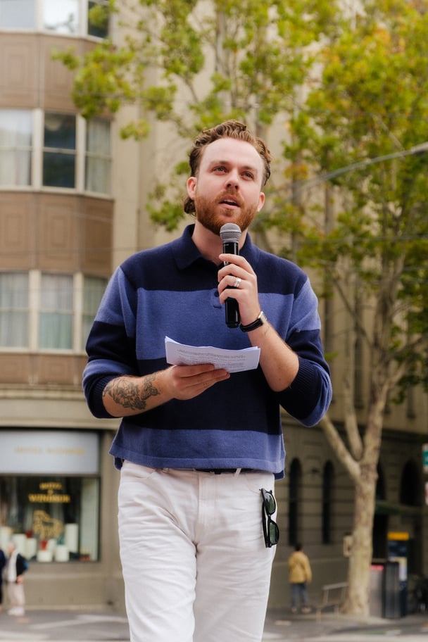 Survivor-activist Harrison James speaking at an event.