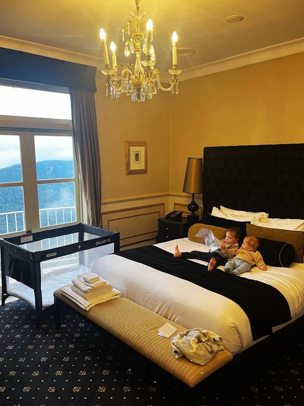 Zoe’s kids resting on the bed during their hotel stay.