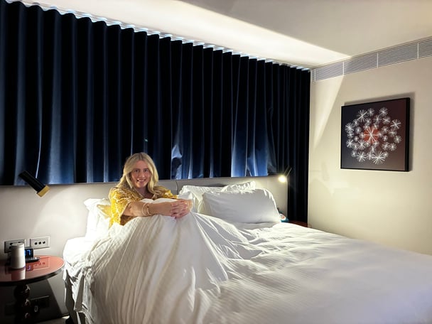 woman sitting in a hotel bed.