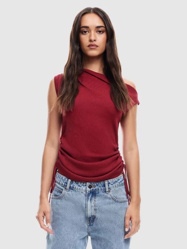 Model in wine coloured off shoulder knit top with side ruching.