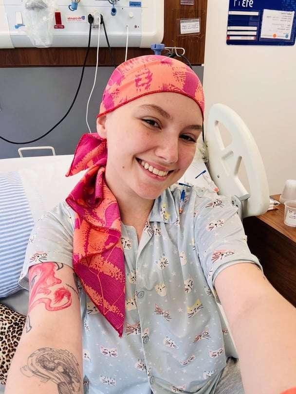 Brazilian influencer Isabel Veloso wears a headscarf in a hospital bed.