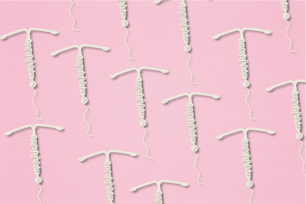 White intrauterine devices on a pink background.