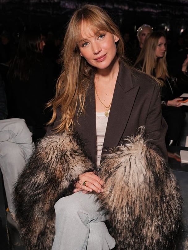 Jennifer Lawrence sits at a fashion show.