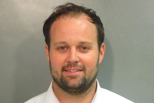 Josh Duggar smiling mug shot.