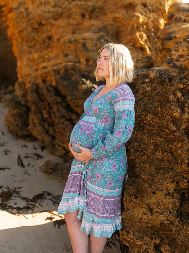Katrina pregnant standing holding stomach.