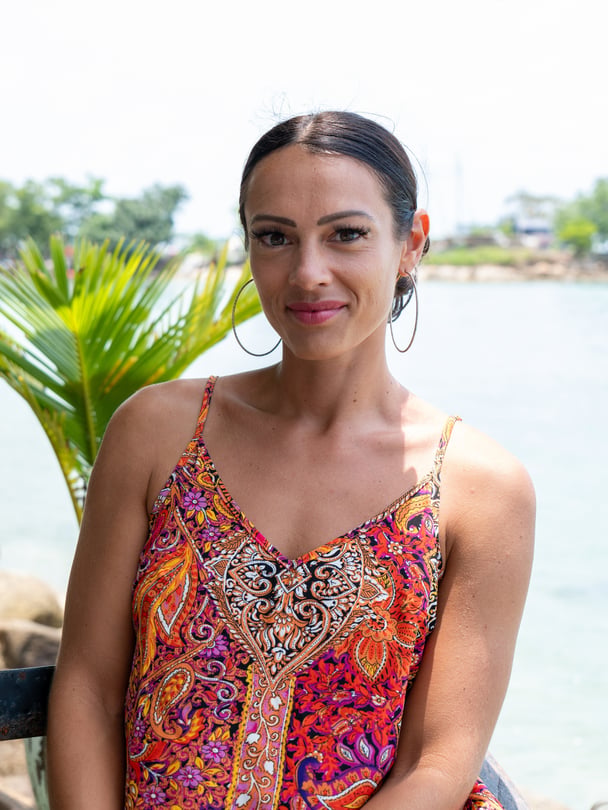 Katy smiling in front of the ocean.