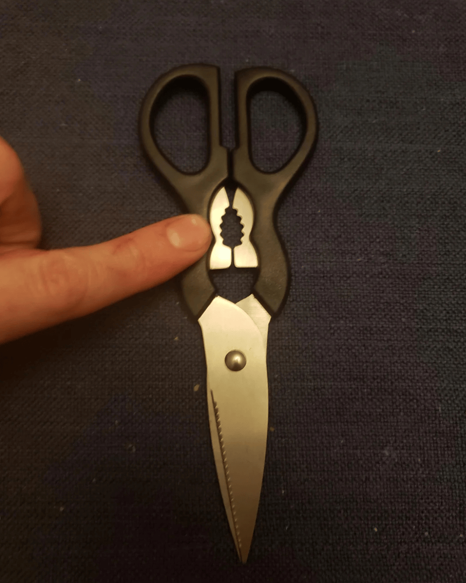 Kitchen scissors or shears have a serrated metal edge that is a multifunctional tool for cracking nuts and opening lids.