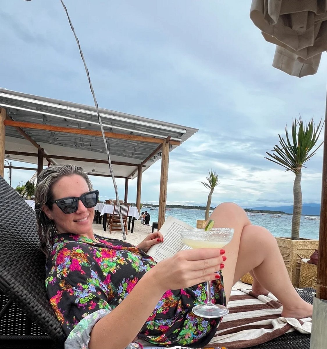 woman on a beach lounge with cocktail