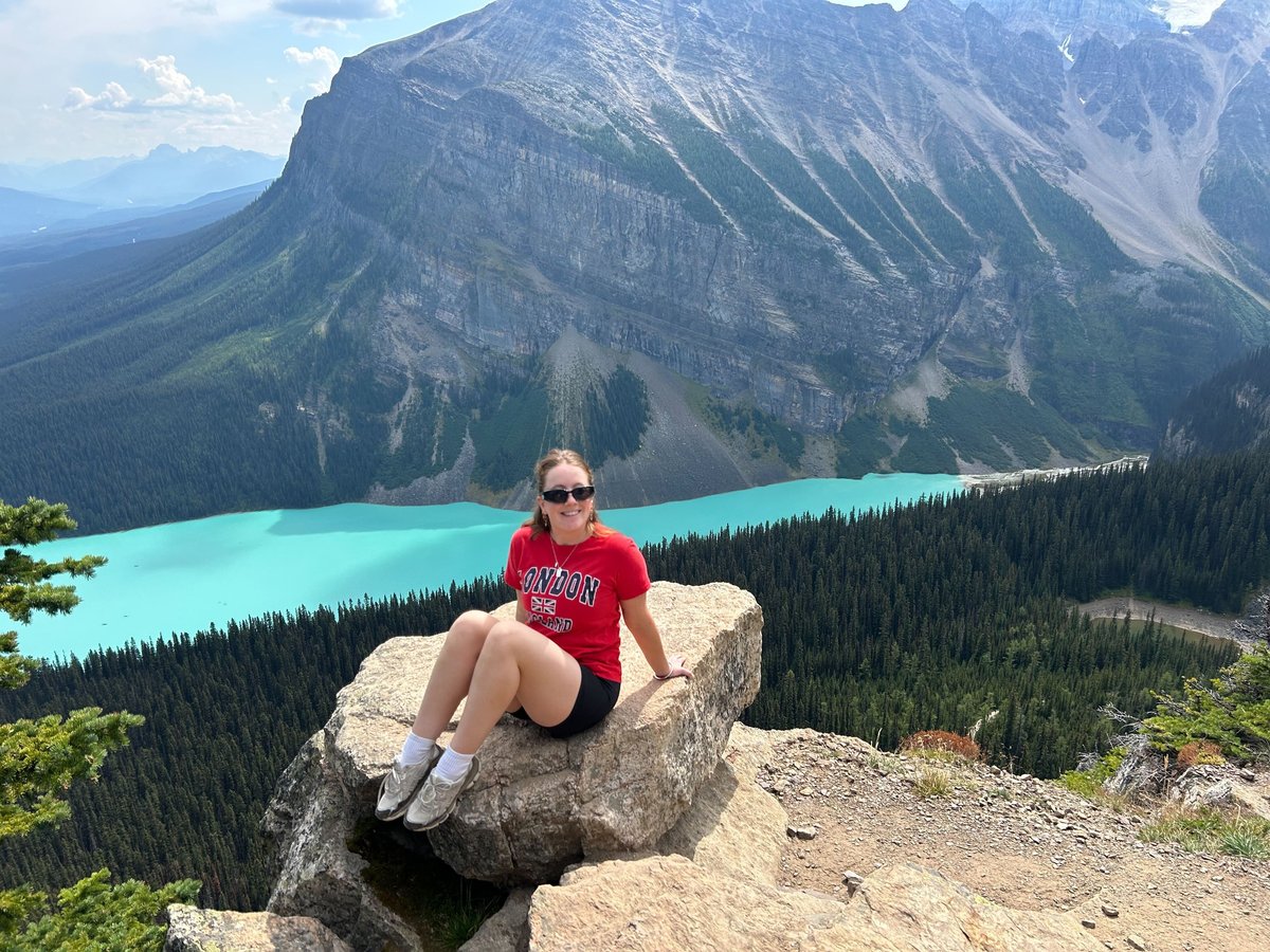 Lucy sitting on a large rock overlooking Lake Louise in Banff.