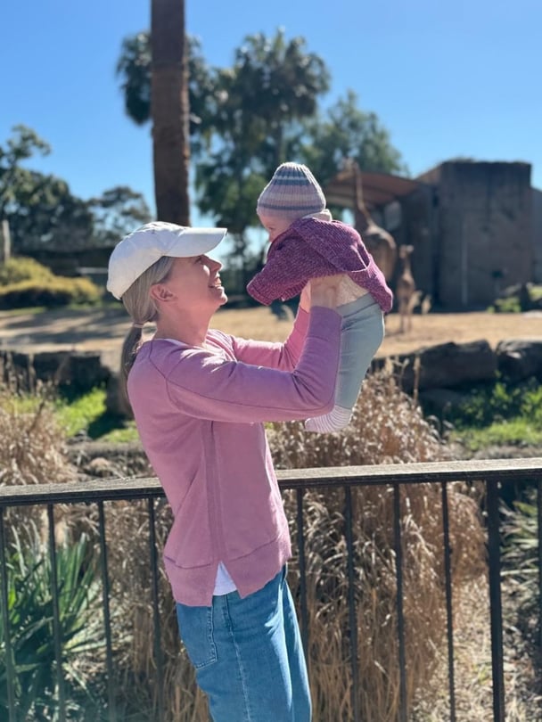 Liv holding baby Gracie in the park.