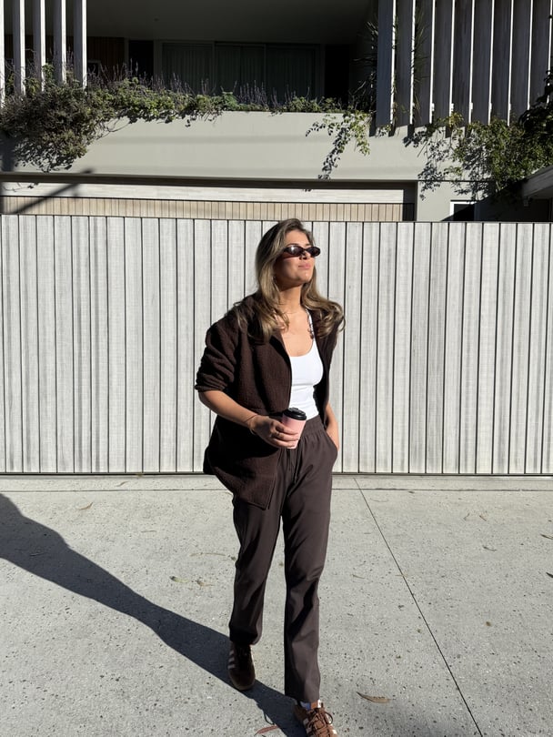 Paige wearing a brown casual outfit and sunglasses.