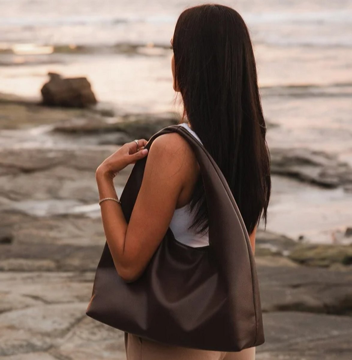 woman wearing chocolate brown beach bag