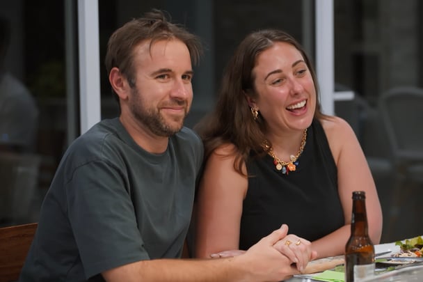 Rachel and Steve holding hands at the table.