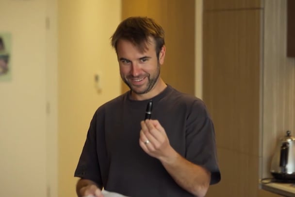 Steve holding up a small, black lipstick.
