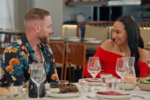 Danny speaks to another woman at the table.