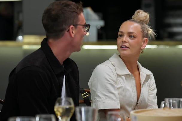 Alissa chats to X at the table.