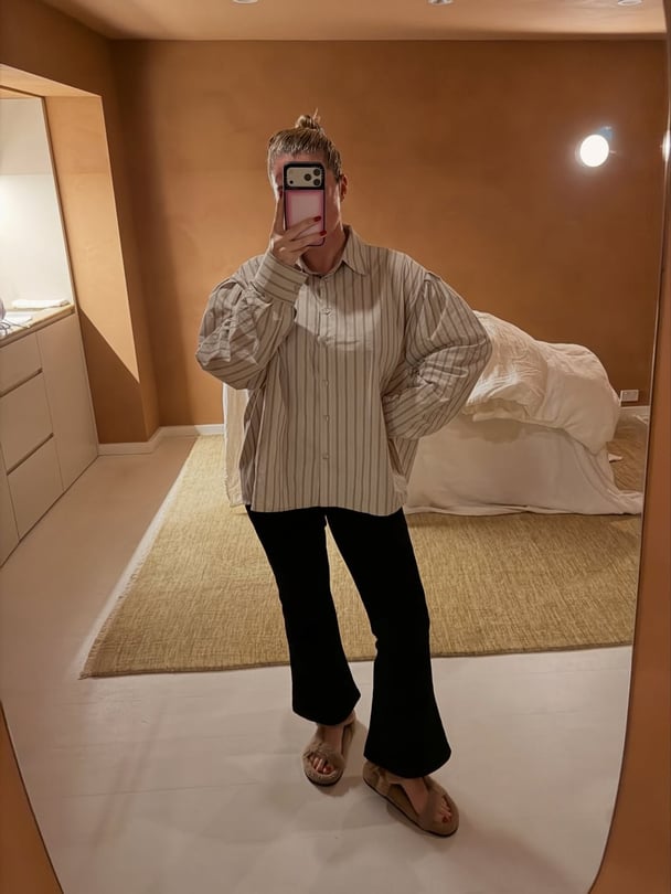 Ali wearing black bottoms from Maggie Marilyn paired with stripe longsleeves and fur sandals.