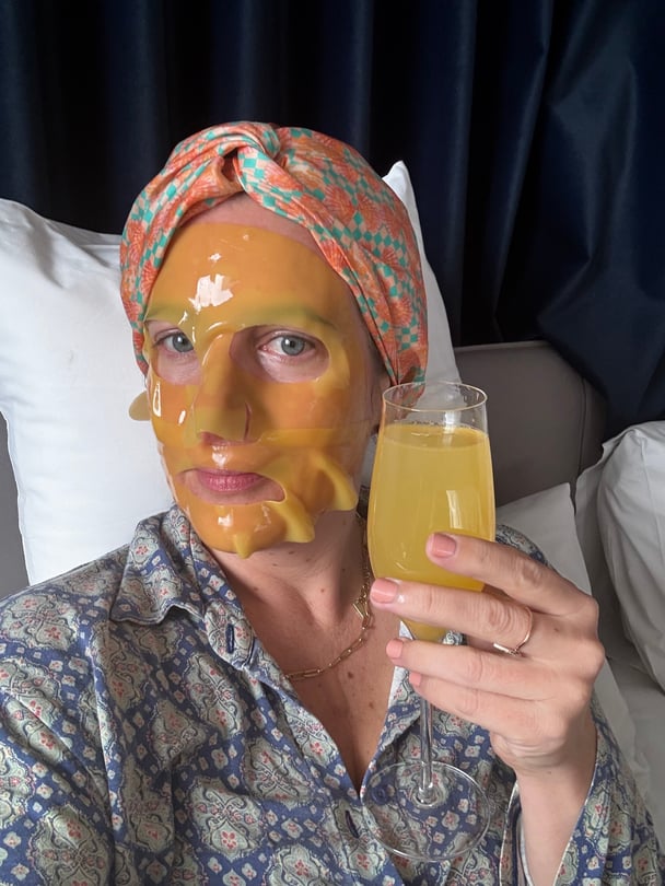 woman wearing face mask in hotel bed