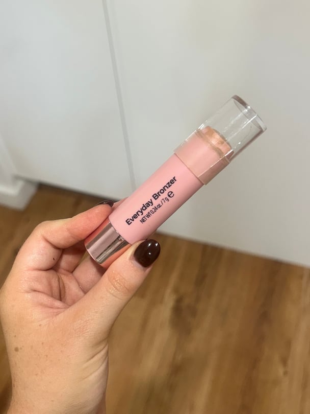 Writer's hand holding the MCoBeauty bronzer stick.
