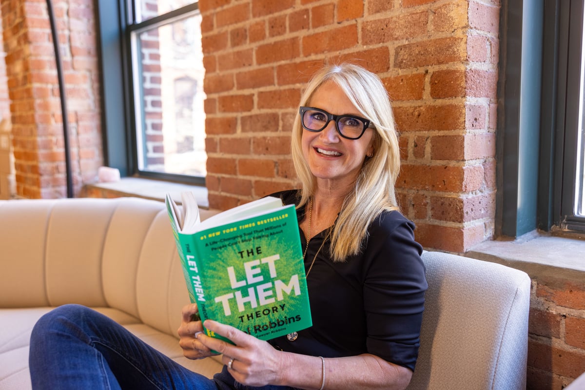 Mel Robbins with her book, The Let Them Theory.