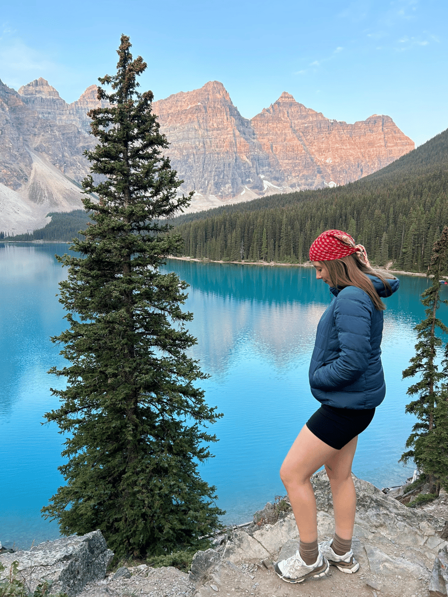Lucy standing in front of Moraine Lake at sunrise.