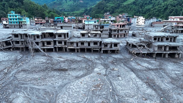 An Aerial view shows debris and mud covering settlements following flash floods on August 29, 2026 in DevGhat village, Nepal.