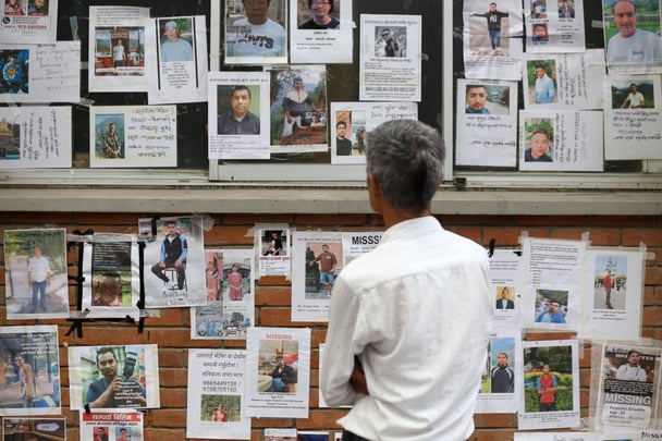 Families and relatives of those missing in the Tibet-Nepal flood check the name images of those missing at the Tribhuvan University Teaching Hospital in Kathmandu.