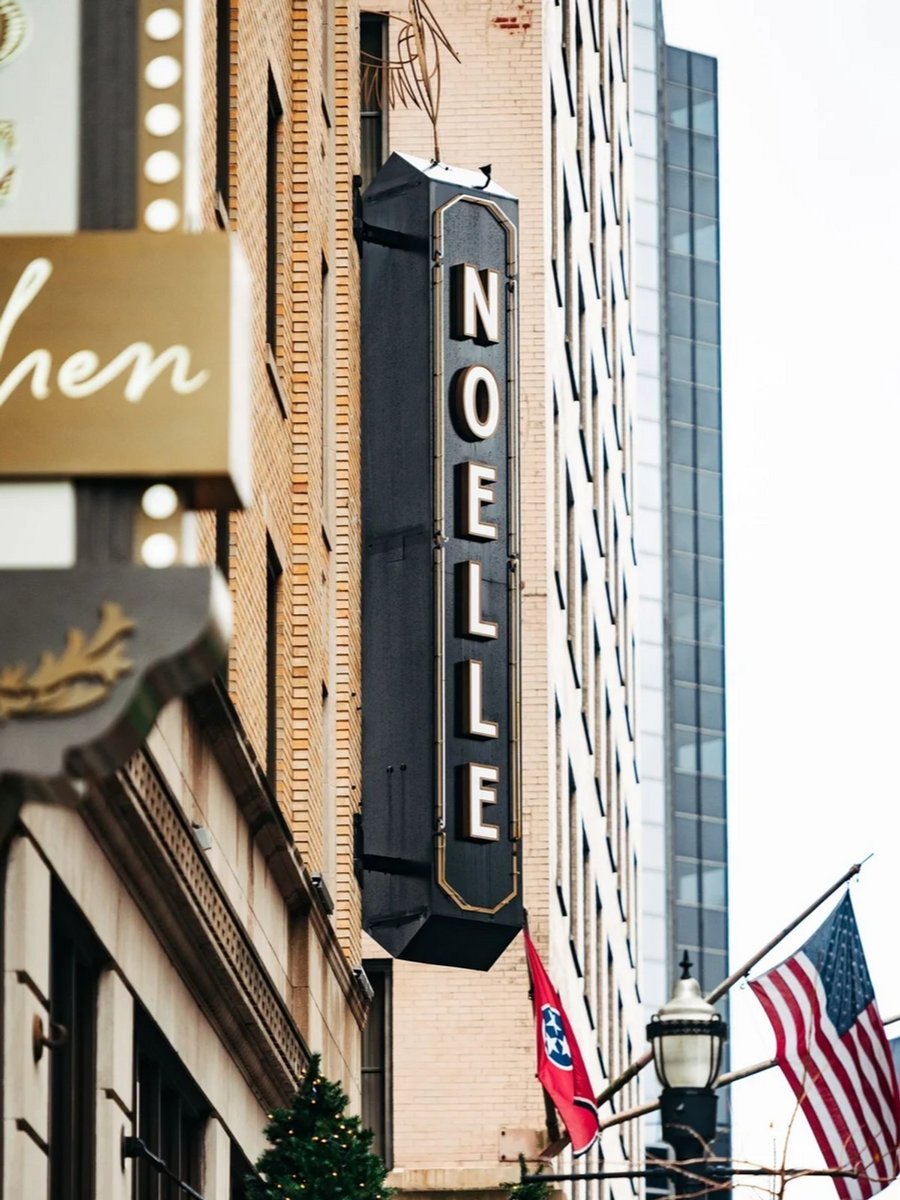 The outside of the Noelle Hotel, Nashville, featuring their sign, the American flag and Tennessee.