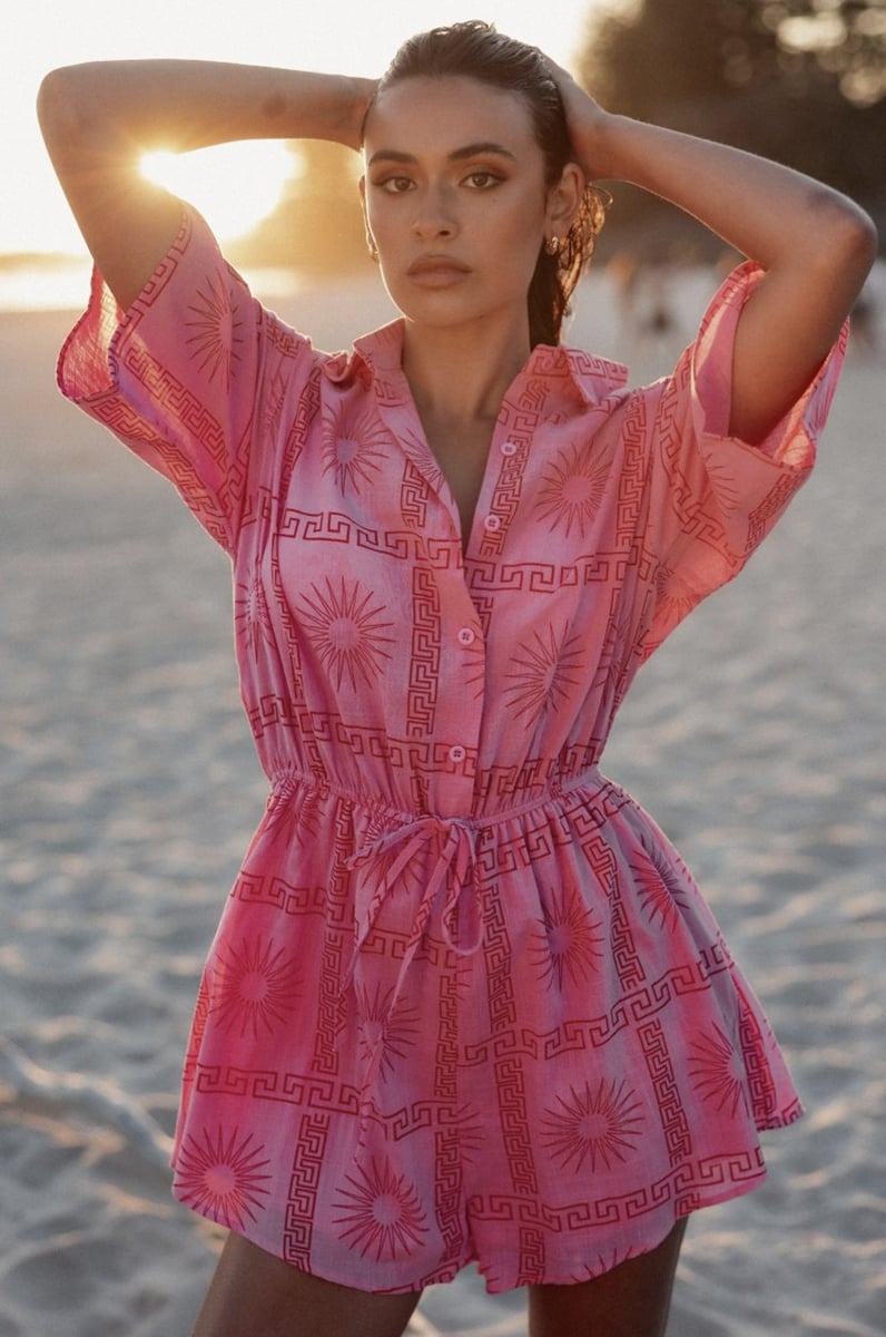 woman wearing pink playsuit from Petal & Pup on the beach