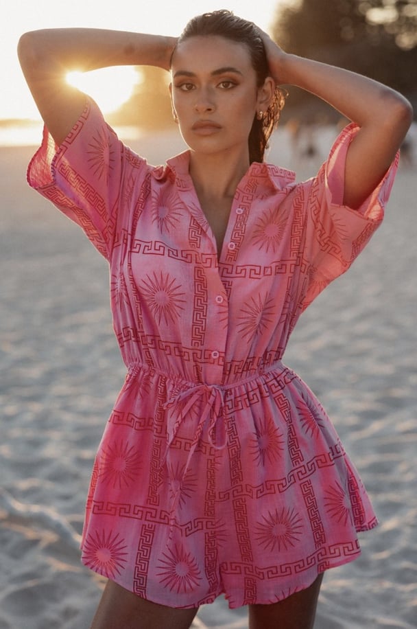 woman wearing pink playsuit from Petal & Pup on the beach