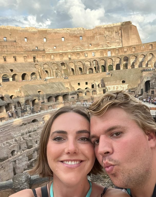 woman and man standing in front of the colleseum in Rome