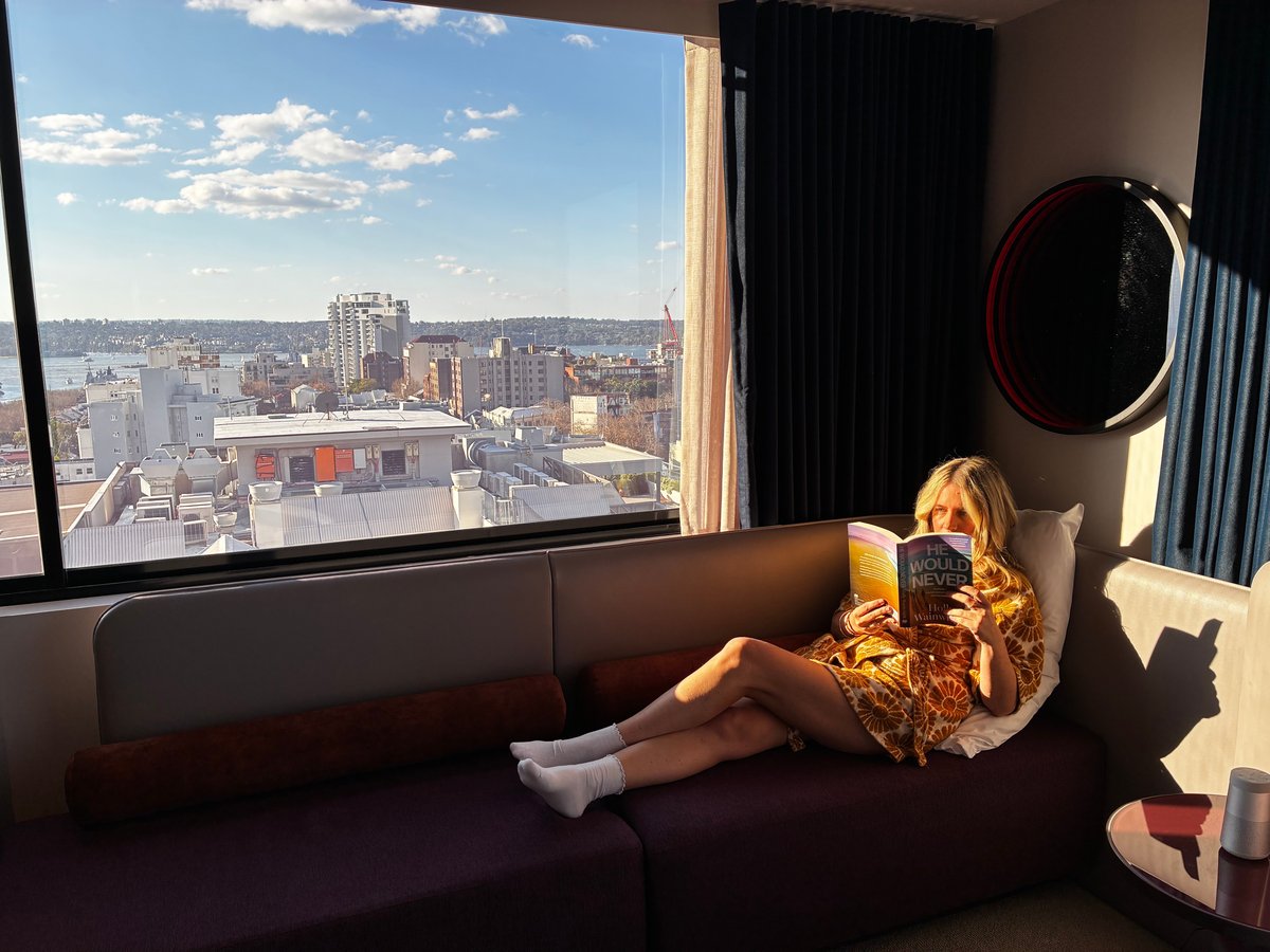 woman reading a book in a hotel room