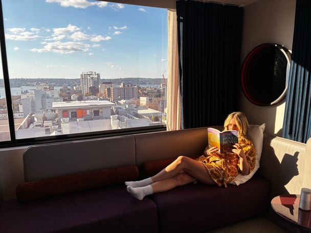 woman reading a book in a hotel room