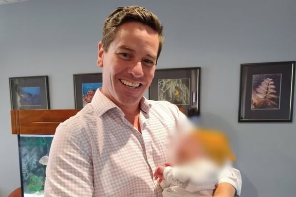 Rhys Henry Stone Bellinge holding a baby.