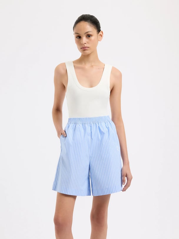 Model wearing white tank with blue striped poplin shorts.