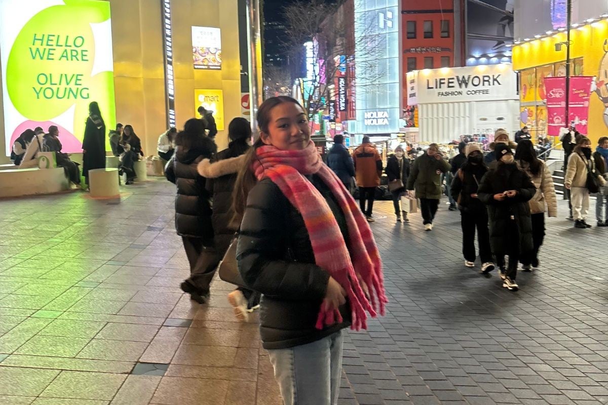 Girl posing in front of shopping street in Seoul, South Korea.