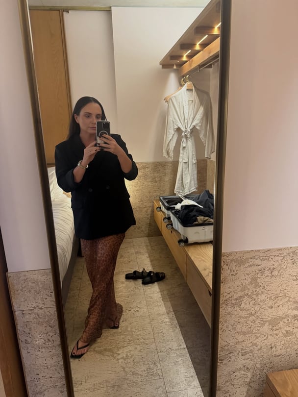 kris-byrnes-mirror-selfie-black-blazer-leopard-print-skirt-hotel-room