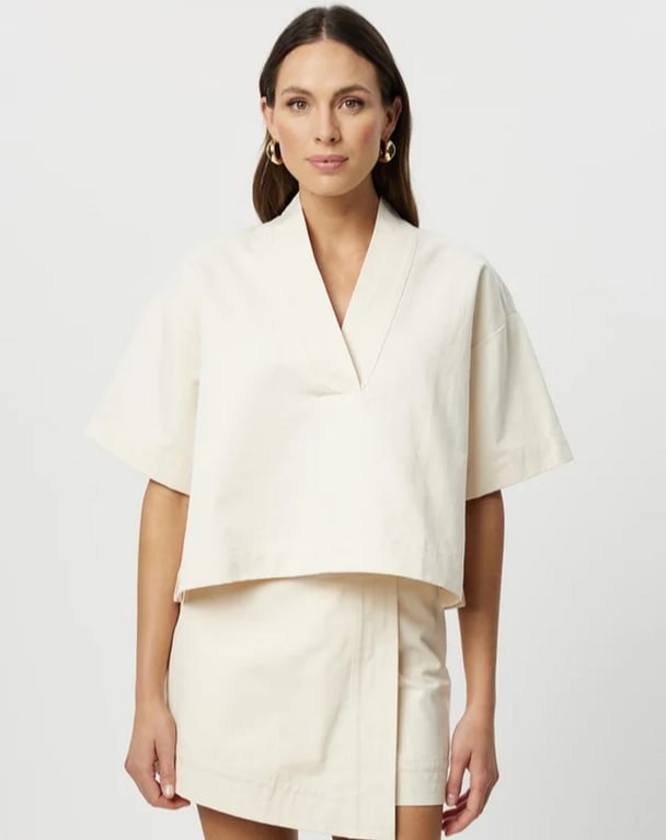 woman wearing Carlotta white blouse and white skirt