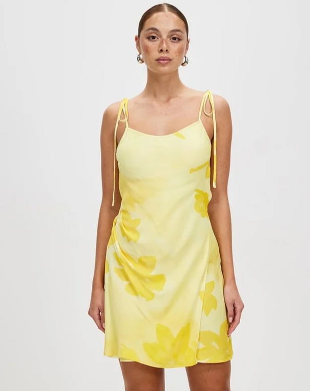 woman wearing short butter yellow dress with flowers on it Third Form Wild Flower Wrap Mini Slip