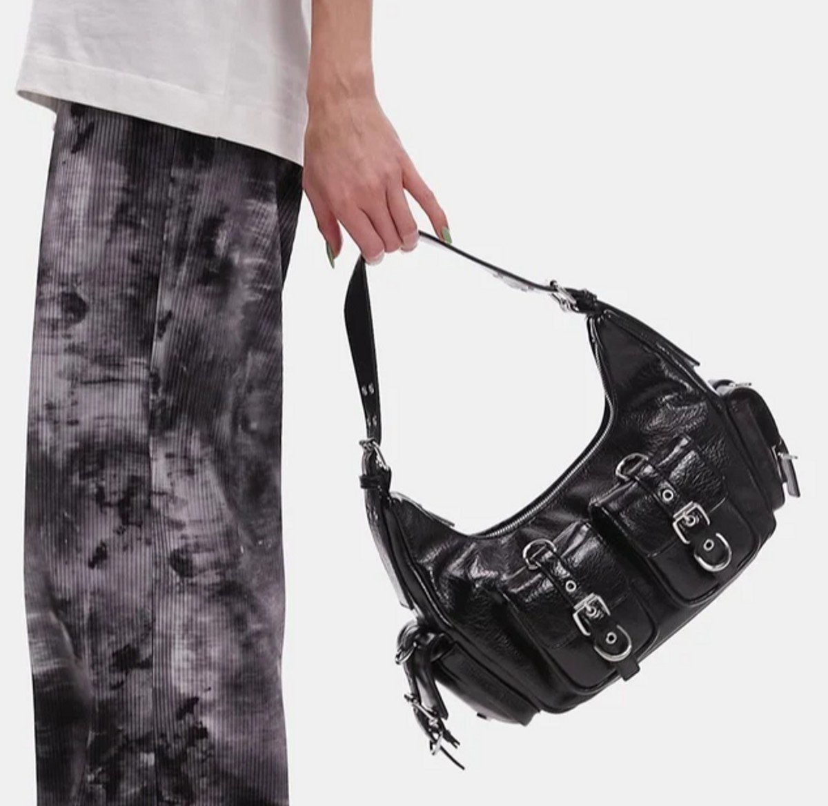 woman holding shoulder bag with buckles 