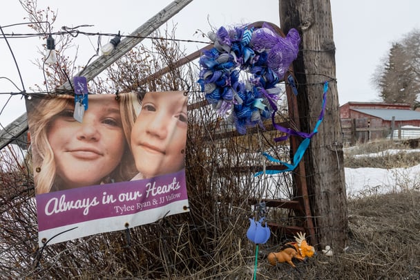 A picture of Tylee Ryan (L) and J.J. Vallow is seen on a fence opposite the property where their bodies were found in 2020