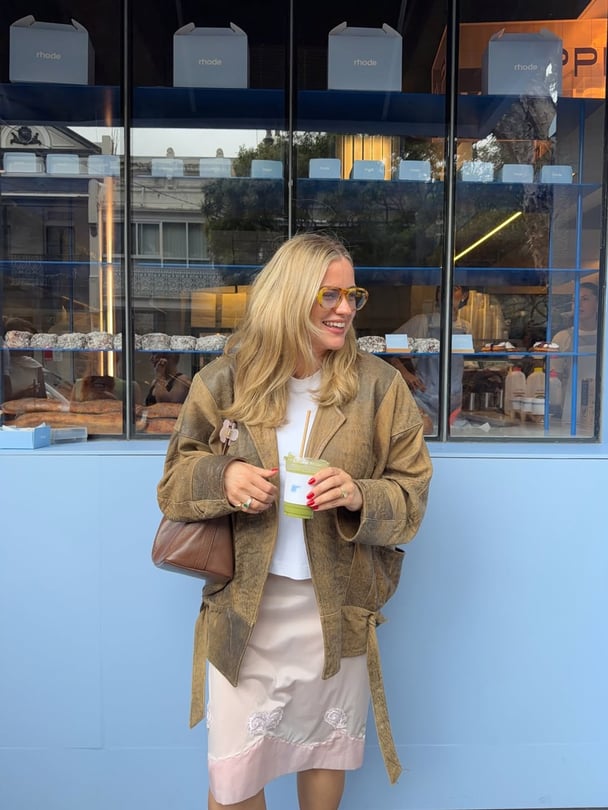 Ali wearing a vintage jacket styled with a white top and a pink embroidered skirt.