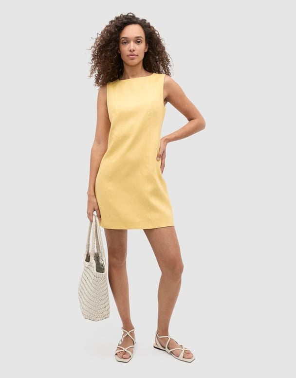 Model wearing yellow linen mini dress.