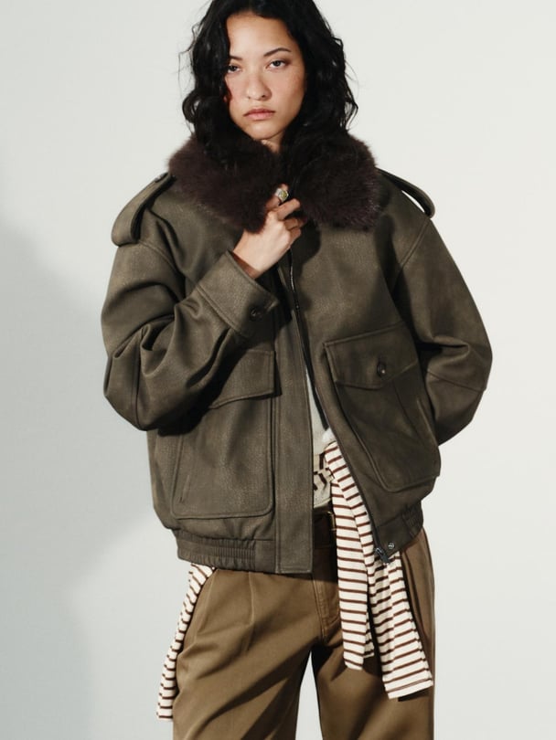 Model in suede jacket with fur collar.